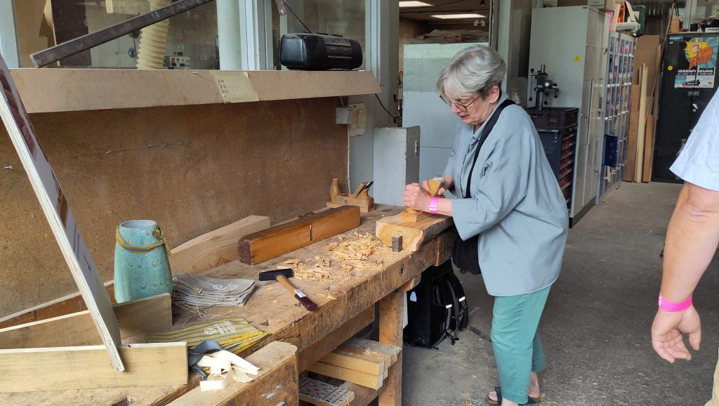 Besucherin hobelt Zedernspäne